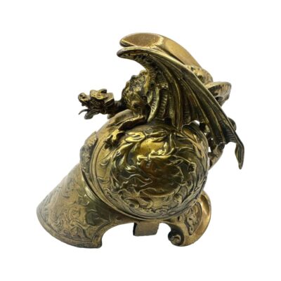 Victorian Brass Helmet Dragon/Griffin Inkwell. The pot which contained the ink is missing but does not deflect from the fine quality and workmanship of this piece.  COLLECT FROM STORE ONLY. Main photo of helmet inkwell seen from a side view showing the shape of the helmet and the dragon/griffin on top with wings spread.