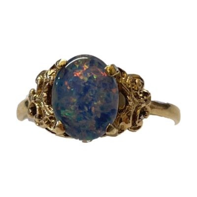 Fine quality 9 karat gold ring set with a black opal cabochon. The doublet triplet black opal emits flashes of pink, yellow & green and measures approximately 18mm by 9mm. Ring size O / 7.25. Main photo of ring seen from the front with no direct light on the black opal