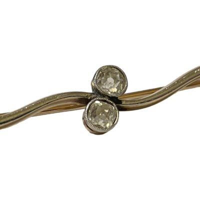 Edwardian 18 karat gold twist brooch with .40 carat diamond. Elegant bar brooch with 18 karat white gold twist front set with 2 old cut round diamonds. Back of brooch in yellow gold. Unusual design secure clasp. No marks but tested for 18 karat gold. Close up photo of the 2 old cut diamonds at the centre of the bar brooch.