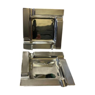 Pair of vintage sterling silver ashtrays. Identical pair of Birmingham assayed sterling silver ashtrays made by Barker Ellis silver company c1989. Both in very good condition with minor dinks and one has a slightly misshapen corner. 177grams. Main photo of both ashtrays with one at the back placed upright on a display stand and other placed in front.