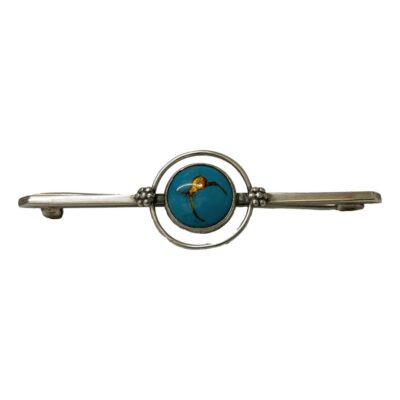 Unsigned sterling silver brooch by Bernard Instone. Simple and elegant Art Deco bar brooch with blue and gold enamel disc to the centre. Hallmarked sterling silver to the back. Inner disc area with enamel measures 9mm and outer circle measures 14mm. Main photo of brooch seen from the front.