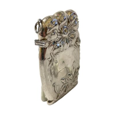 Art Nouveau style sterling silver vesta case. A generously sized vesta match case in 925 sterling silver with a lovely floral design very typical of Nouveau era. Stamped 925 on inner rim, this vesta looks as though it has never been used hence dating as modern. Very likely for use on a chatelaine with a ring clasp to the side. Photo of vesta with the ring clasp and hinge side in the foreground to the left. The photo is taken with the vesta set at a diagonal angle.