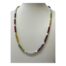 Modern necklace set with multiple semi precious gem stones. Colourful beaded necklace with alternating rows of garnet, amethyst, carnelian, moonstone, peridot & citrine with freshwater pearls and gilt bead separators. Finished with a gilt metal barrel clasp. Main photo of necklace displayed on a stand and seen from the front.