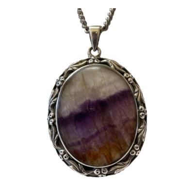 Vintage Blue John sterling silver pendant and chain. A nice sized oval Blue John in a pretty sterling silver setting with berries & leaves forming the frame. Set on a long chain with no clasp. Hallmarked to the pendant bail for Birmingham assay. Pendant drop length 52mm from top of bail. No hallmark to the chain. Close up photo of the pendant shown straight on forward facin.