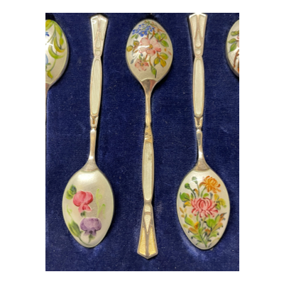 Vintage Henry Clifford Davis Birmingham silver and enamel boxed set of 6 coffee spoons hallmarked c1959. Beautiful enamel detail with a different flower design to back of each spoon. There is a slight blemish of the enamel to one spoon at the handle. Each spoon measures 80 x 0.5 x 15 mms. The measurements below are for the box. Close up showing 3 of the 6 spoons with spoon with blemish to enamel in the centre.