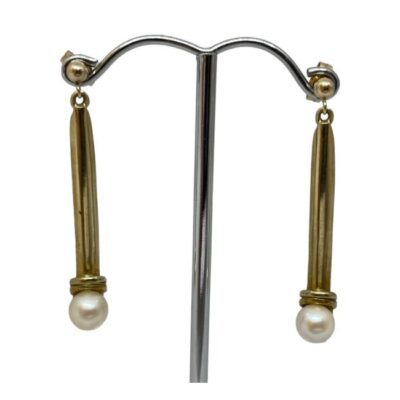 Vintage 9 karat gold and pearl earrings. Stylish and elegant pair of vintage 9 karat gold earrings with a pearl to the ends of each. The gold setting is solid so the earrings hang straight. Hallmarked to both earring pins and 9ct on the butterfly fasteners. Drop length 40mm. Weight 3.7gms. Main photo showing both earrings displayed on a silver coloured display stand facing forward.