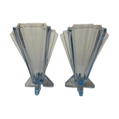 Pair of Art Deco small blue glass vases. Lovely pair of identical small light blue glass vases in a classic Art Deco shape. Thinner at the base with fan like shape to the top. Base measures 65mm by 58mm, top at widest measures 90mm, depth at 48mm. (515gms). Photo of both vases shown side by side with full sides visible of both. (like 2 fans open and side by side)