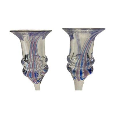 Pair of Art Deco liqueur glasses. Pretty pair of funky Art Deco liqueur glasses with pink and blue candy stripes flowing from one side to the other. A nice weighty glass with double ridge to the glass bottom making them very easy to hold. As they are handmade, there is a slight size difference as well as colour/width of the blue and pink stripes. Measures approximately 52mm at base, 45mm at top and 140mm tall. Close up of the top half of both glasses showing the candy stripes and the ridges at the base of the glasses at top of stem.