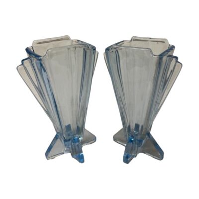 Pair of Art Deco small blue glass vases. Lovely pair of identical small light blue glass vases in a classic Art Deco shape. Thinner at the base with fan like shape to the top. Base measures 65mm by 58mm, top at widest measures 90mm, depth at 48mm. (515gms). Main photo of both vases shown with fan side facing slightly inward so at a diagonal angle.