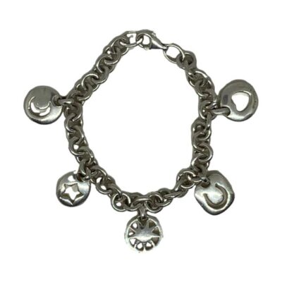 Vintage Tiffany & Co charm bracelet in sterling silver. Heavy charm bracelet by Tiffany & Co with sun, moon, star, heart and horseshoe charms. Tiffany & Co stamp on heart charm only and hallmarked 925 to the clasp. Charms measure approximately 20mm drop length and 15mm wide. Weight 40gms. Photo of bracelet displayed on a flat surface in a circle shape with clasp closed.