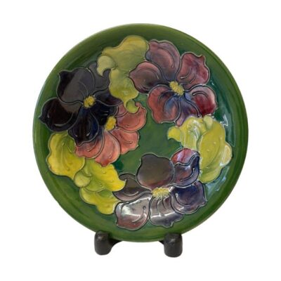 Large Moorcroft bowl in clematis pattern. A generously sized William Moorcroft bowl decorated in clematis pattern c1947-1953. Very slight mis-glazing in a couple of spots otherwise in excellent condition. Measures 250mm in diameter across top, 90mm at the base and 55mm tall. Main photo showing the bowl displayed on a stand so upright looking fully at bowl centre with the purple and pink clematis flowers and leaves all the way round.