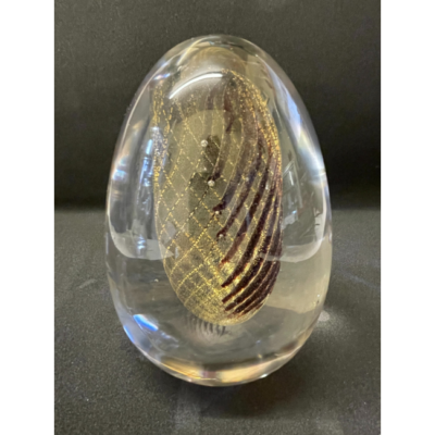 Vintage egg shaped paperweight by Murano. A clear glass mid sized egg shaped paperweight with an inner 3 dimensional image which is only clearly visible in a certain light and angle. The inside form is of purple/brown stripes to one area which are connected to almost invisible golden strands. A truly wonderful piece of art by the great Murano glass master Archimede Seguso. Signed to the base. Heavy item - collect from store only. Base measures 30mm in diameter. Photo of egg paperweight from another angle to show the purple/brown stripes at one side of the inner golden strand egg.