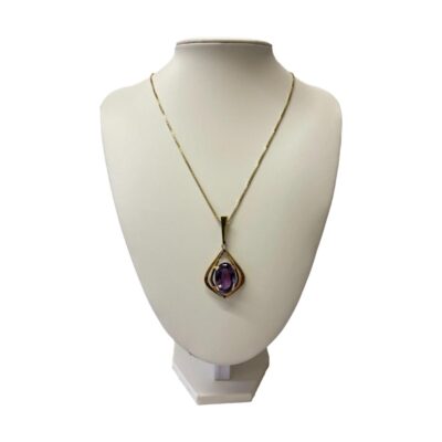 14 karat gold chain with amethyst pendant. Classically stylish 14 karat gold pendant with a modern twist, set with a large oval cut amethyst. Hallmarked to back of pendant and to chain clasp and ring hook. Pendant measures 67mm long and 28mm at widest. Main photo of necklace displayed on a stand with the pendant facing full forward.