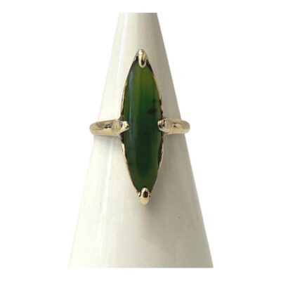 10 karat gold and jade ring. Vintage ring with a long eye shaped jade set in 10 karat gold. Jade size 26mm long and 6mm at widest. 10k hallmark to inside band. Ring size O / 7. Main photo of ring displayed on a cone shaped stand with the ring front facing forward.