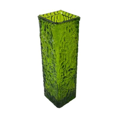 Art glass vase by Davidson. A green British glass vase in a bark like texture. Often mistaken for Whitefriars, this vase design from the Luna range, was made by Davidson in 1966 after they became Brama Teams Glassworks. Photo of vase seen from a slightly raised angle with one corner edge of the vase in the foreground. The raised angle shows 2 of the vases sides and the mouth of the vase.