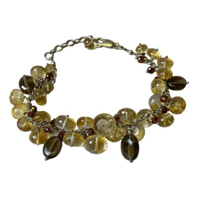 Sterling silver quartz crystal bracelet. Vintage bracelet set with faceted quartz, smoky quartz and tiny faceted cranberry quartz beads. Hallmarked 925 to the clasp. Length adjustable from 185mm to 215mm. Main photo of bracelet laid on a flat surface in a circle with clasp closed..
