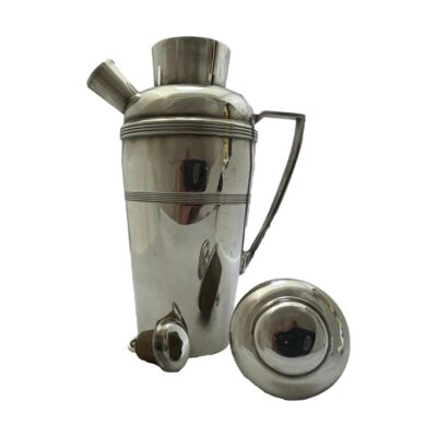 Silver plate cocktail shaker. Small silver plate cocktail shaker with pouring spout. All original lid and spout cover. In fair condition for its age with some signs of wear to the silver plate. Recommend cleaning before use. Photo of shaker with lid and spout stopper removed and placed in front of the main body of the shaker top side on display.