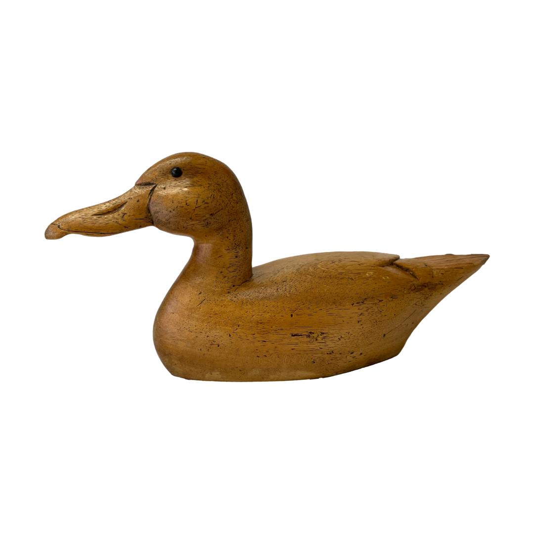 Decoy duck by Wisemans. Beautifully crafted vintage wooden decoy duck with incredible attention to detail to the ducks features & contours. Wisemans Decoy engraved to the side. Main photo of the duck seen from a side angle. The head and incredible beak is on the left and tail feathers to the right.