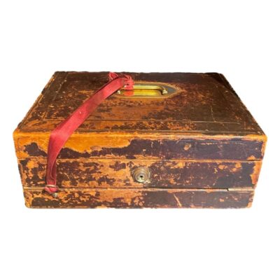 Antique correspondence box c1869-1910. Stunning antique correspondence box by Melliship & Harris of Westbourne Grove, London, with brass fittings throughout and original key. Desirable aged patina, leather bound, opening to reveal leather writing skiver, letter storage & 2 inkwells with brass lids. There is a note inside inscribed "To Dorothea from her beloved Papa 1910" Collect from store only. Main photo of box seen closed and from the front. The aged patina of the leather cover is clearly shown with considerable wear especially on the lefthand side. There is a red ribbon tied from the brass handle in the centre of the box top which holds the original key.