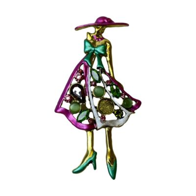 Modern brooch/pendant of a vogue lady. Fun brooch of a fashionable lady dressed in a vogue style. Main colours of attire in turquoise green and magenta pink strikingly set against a gilt metal body. The skirt of the dress is made up of different shaped glass stones which have colours complimenting the 3 main colours of the brooch. Main photo of brooch in its entirety> The vogue lady is standing upright with a magenta pink wide brimmed hat on, her face, neck, shoulders and arm (only one showing) are in gilt metal a large turquoise green bow covers her breast area followed by a knee length A line skirt with 2 magenta pink panels and one silvery white. These panels are adorned with different coloured glass stones. Her legs are also gilt metal in colour and her shoes with heels one pointing out to the side and other pointing forward are in turquoise green. It is a rather fabulous piece of statement jewellery.