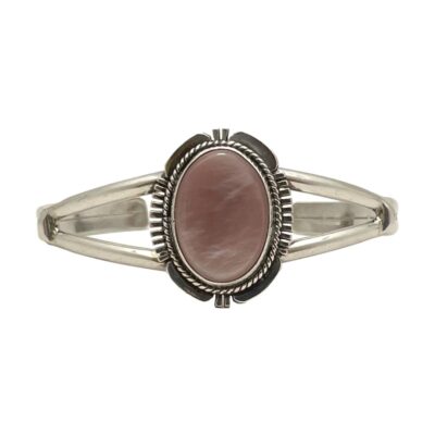 Navajo signed cuff bracelet in sterling silver. Fine quality native American sterling silver cuff bracelet with pale pink shell to the centre. The shell is housed on a solid silver mount with a recognised Navajo frame design. Signed J. Nelson and sterling to the back. The central area measures 28mm by 22mm. Main photo of bracelet with the front forward facing. The shimmering pink of the shell contrasts beautifully against the sterling silver. The cuff has split shoulders which taper to a single band at the cuff ends.