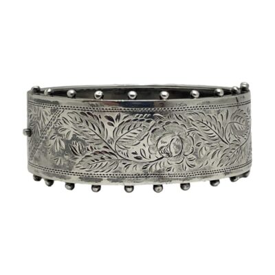 Victorian bracelet in sterling silver. A lovely antique bracelet with one side etched with a single rose to the centre and surrounded with foliage and opposite side in plain silver. Finished with little ball like protrusions along both edges of the etched side. Hallmarked to the inside of both halves for Birmingham assay c1884. Photo of bracelet laid on its side with the etched silver side only only show.
