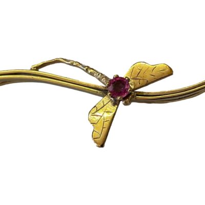 Gold bar brooch with garnet set dragonfly. Pretty 9 karat gold bar brooch with a sweet little dragonfly to the centre set with a single round cut cerise garnet. Hallmarked 9ct to side of bar. The dragonfly measures approximately 17mm long with wingspan of 16mm. Close up photo of the dragonfly with a clear shot of the cerise pink garnet as thorax.