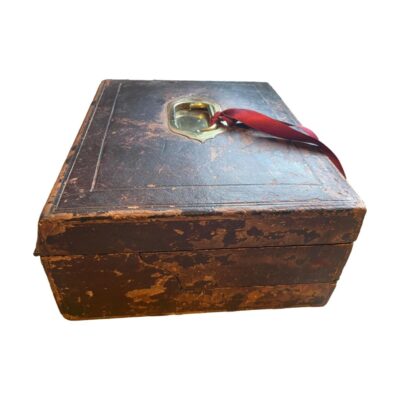 Antique correspondence box c1869-1910. Stunning antique correspondence box by Melliship & Harris of Westbourne Grove, London, with brass fittings throughout and original key. Desirable aged patina, leather bound, opening to reveal leather writing skiver, letter storage & 2 inkwells with brass lids. There is a note inside inscribed "To Dorothea from her beloved Papa 1910" Collect from store only. Photo of box seen from the side to show the 3 tiers.