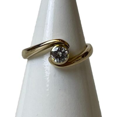 Vintage 9 karat gold and diamond ring. Simple yet elegant ring in 9 karat gold with a beautiful single round cut diamond. The split twist band evokes an image of 2 arms caressing the diamond. Fully hallmarked to inside band for London assay c1990. Ring size J / 4.75. Main photo of ring on a cone shaped display stand with the ring front facing forward. The shoulder of band on the left ends atop the diamond and the right hand band below.