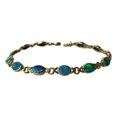 9 karat gold bracelet with black opals. Stunning bracelet in 9 karat gold with 12 colourfully live Australian black opals. Fully hallmarked to the clasp. Measures 195mm long and 6mm wide. Main photo of bracelet displayed in a circle and seen with half the black opals on display in the foreground and back of other stones in the background. The colour play in the stones is incredible with bright blue, turquoise, green and yellow.