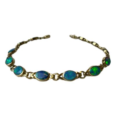 9 karat gold bracelet with black opals. Stunning bracelet in 9 karat gold with 12 colourfully live Australian black opals. Fully hallmarked to the clasp. Measures 195mm long and 6mm wide. Photo of bracelet laid on a flat surface in a circular pattern. The clasp area is in the background and shown undone.