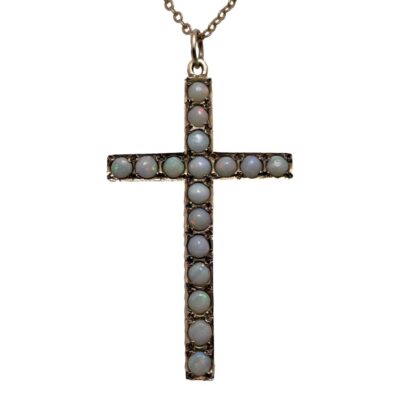 9 karat gold cross with opals on chain. Pretty rose gold cross embedded with opal stones which have a subtle colouring with bright flashes in certain light. Both the cross and chain are in rose gold with a hallmark of 9 karat to the yellow gold clasp only. The cross measures 48mm long from top of bail and 26mm wide. Close up photo of the cross with the subtle colours of the opals visible.