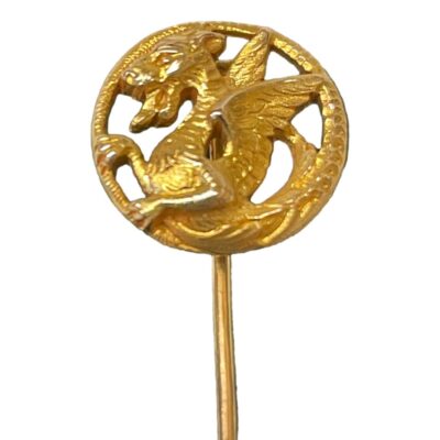 Victorian gold stick pin with griffon. Antique 18 karat gold stick pin with a griffon disc to the tip. The head, forelegs and wings of the griffon are to the centre with tail acting as the frame. Hallmark is worn but 18k is just visible to the top of the pin. Measures 68mm long and the griffon disc is 15mm in diameter. Weight 4.9grams. Close up photo of the griffon at the tip of the pin. It could actually be a dragon as much as a griffon. It is in profile facing left with its fore arms seeming to be clutching the ring that the griffon is framed in with wings on opposite side of the ring. The ring is actually the tail of the griffon wrapped round like a frame.