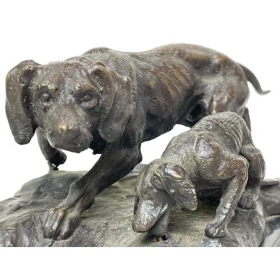 A signed bronze of hunting dogs. Handsomely made bronze of an adult hunting dog with pup, the adult being on high alert. Signed Barye to the base of the bronze which is set on marble. The signature is unverified hence listing as inspired by Barye. Measures 225mm at longest, 150mm at widest and 105mm at tallest. Weighs 2960grams. Collect from store only. Close up photo of the dogs showing the adult looking straight to camera on high alert while the pup is eating or drinking.