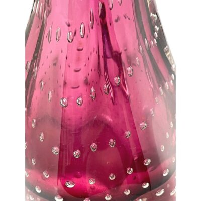 Close up photo of some of the controlled bubbles within the magenta glass.