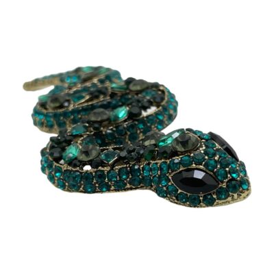 Main photo of brooch seen with snakes head in the bottom right foreground and the end of tail in the top left background. The different green and blue coloured crystals and varying shapes is clear,