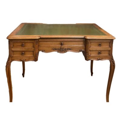 Vintage French writing table. A very attractive French writing table with carved detail, cabriole legs and green tooled leather top. 2 small drawers to the left and right and one drawer to the centre with a single key which locks all drawers. Height 745mm. Desk top measures 995mm by 600mm to the sides and 540mm in the middle. Legs at widest bowed area 1005mm by 595mm. Collect from store only. Photo of writing table seen from the front with beautiful bowed cabriole legs to the front and green tooled leather to the top. 2 small drawers to the left and right one above the other and larger drawer to the centre. An inspiration to get to work if ever there was one! A beautiful piece of French furniture.