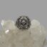 Main photo of ring displayed on top of some quartz crystal and seen with ring front facing forward. The marcasite pieces are catching the light and sparkling nicely. The design of the front is very Art Deco. A diamond shape at the centre holds one marcasite. The overall shape of the front is rectangular but without sharp edges .