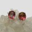 Main photo of earrings displayed on top of a cluster of quartz crystal with the earrings fronts forward facing. The azotic mystic topaz stones are beautifully facet cut ovals with an array of different colours in an assortment of pink hues.