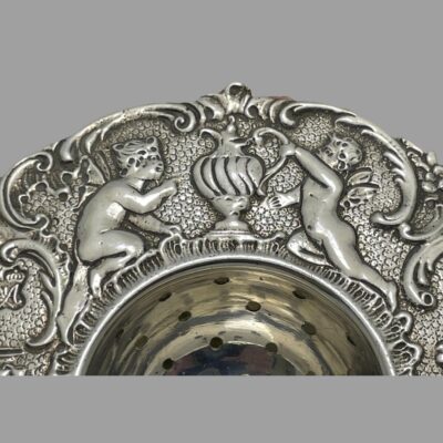 Close up photo of the cherubs at the top tending the tea pot.