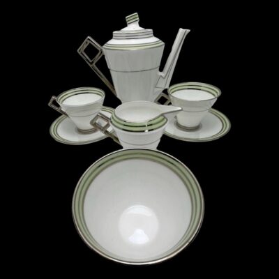 Main photo of whole set displayed together against a black background which enhances the colouring of the set which is mostly white with pale green and silver accents to the rims. The coffee pot is in the background with the 2 cups and saucers to either side. The milk/cream jug is next in front of the cups then the sugar bowl is right at the front.