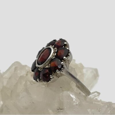 Photo of ring displayed on a cluster of quartz crystal and seen with the ring front facing left and up.