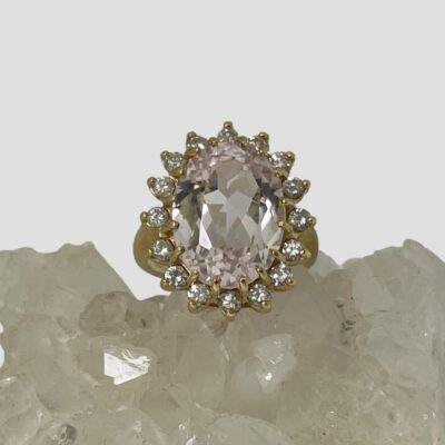 Main photo of the ring displayed on top of some quartz crystal with the ring front facing forward. The diamonds are shining beautifully.