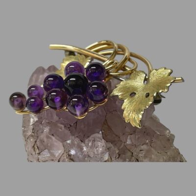 Secondary photo of brooch still on top of the natural amethyst and seen from a diagonal angle showing depth. Only one vine leaf is visible.