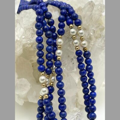 Close up photo of the mid sections of the strands showing the pearls which are separated with small round gold beads and the lapis beads which have no dividers.