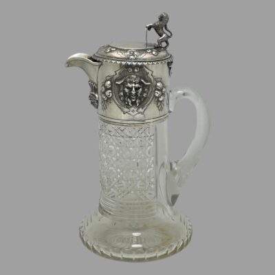 Main photo of jug seen from a side angle from an eye level. The spout is to the left and handle to the right. The hob nail cut to the crystal is clearly displayed.