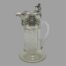 Main photo of jug seen from a side angle from an eye level. The spout is to the left and handle to the right. The hob nail cut to the crystal is clearly displayed.