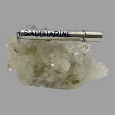 Main photo of the tube laid horizontally across a cluster of quartz crystal. The enamelled blue saccharine side is on display. The opening end is to the right and the ring clasp for possibly attaching to a châtelaine is on the left. As per the description, this item can be used for holding other useful items like toothpicks, a sewing needle and some thread-anything that will fit!