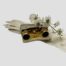 Main photo of opera glasses displayed inside their case. The case is laid flat with the cover open displaying part of the glasses which are slightly protruding out. The case is on top of a pair of long off white gloves with a small sprig of orchid flowers draped over the top.