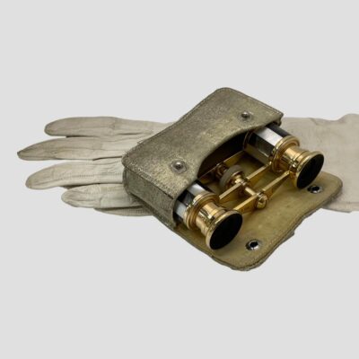 Secondary photo showing the opera glasses protruding from the open case which is laid flat on top of a pair of long off white gloves..